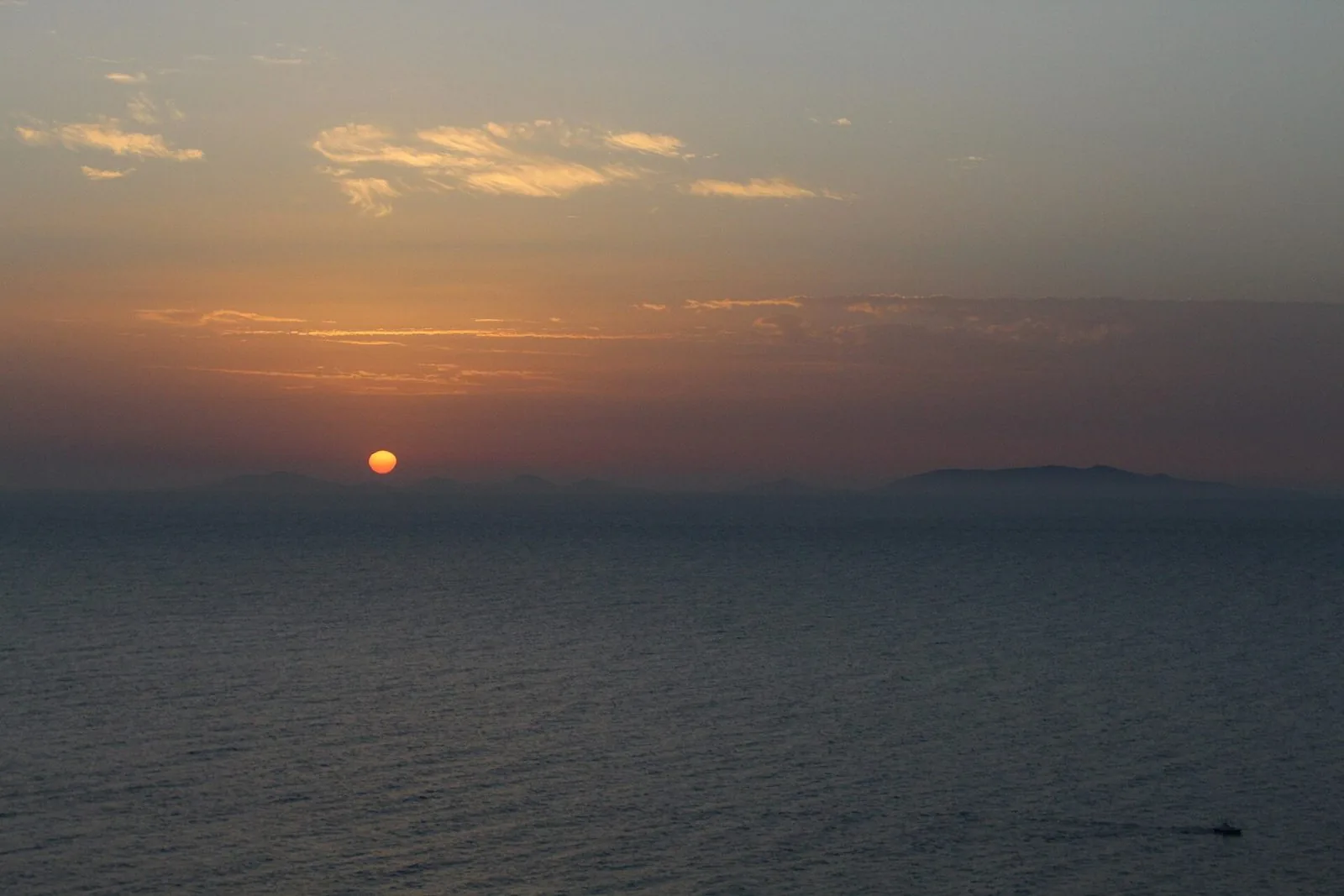 Tramonto sul Golfo dell'Asinara visto da Castelsardo, con il sole basso sull'orizzonte e il profilo dell'isola dell'Asinara